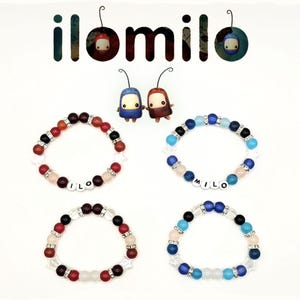 May include: Four beaded bracelets with the name "MILO" spelled out in white letter beads. The bracelets feature a mix of red, black, white, and blue beads. The image also includes the "ilomilo" logo and two small character figures.