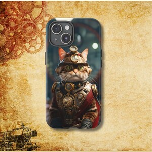 May include: A black phone case with a steampunk cat wearing a helmet and goggles. The cat is brown and tabby with green eyes. The background is blurry and out of focus.