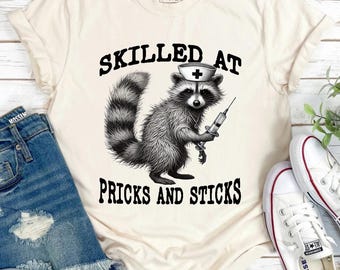 Funny Raccoon Nurse Shirt: Skilled at Pricks and Sticks