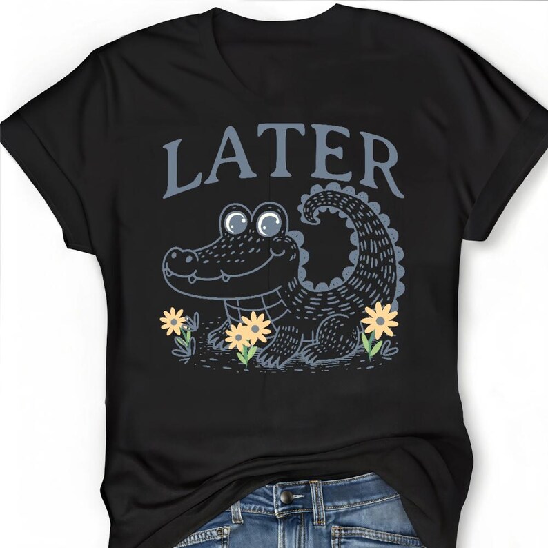 May include: Black t-shirt featuring a cartoon alligator and the word "LATER" in blue text.