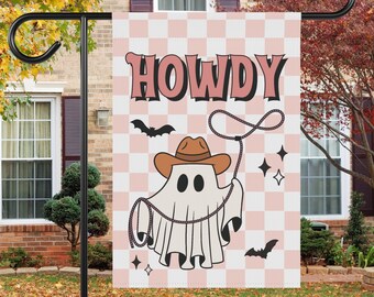 May include: A pink and white checkered garden flag with a ghost wearing a cowboy hat and holding a lasso. The flag says "Howdy" in pink letters.