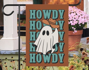 May include: A rectangular garden flag with a brown background features the words "HOWDY" stacked vertically in teal. A cartoon ghost wearing a cowboy hat is in the center. The flag is displayed outdoors on a black metal stand.