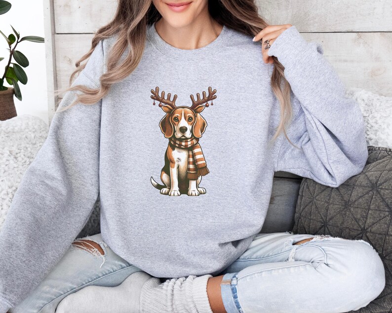May include: A gray sweatshirt with a cartoon beagle wearing a scarf and antlers. The beagle is brown and white with a black nose.