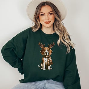 May include: A dark green sweatshirt with a cartoon image of a beagle wearing a brown and white scarf and reindeer antlers.