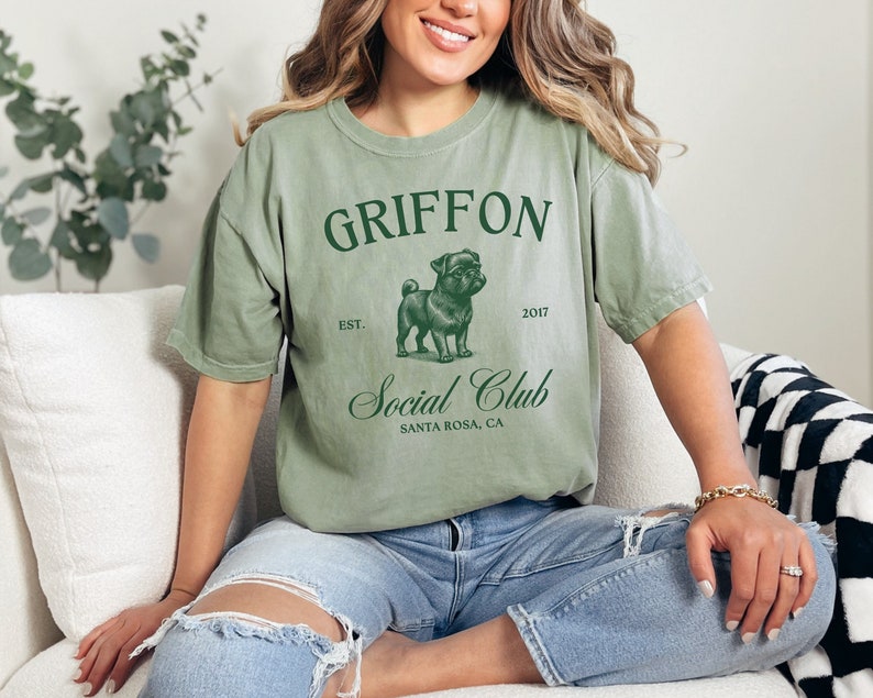 May include: A green t-shirt with the text "GRIFFON Social Club" and a pug illustration. The text "EST. 2017" and "SANTA ROSA, CA" are also printed on the shirt.