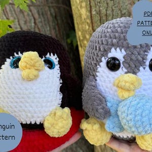 Puede incluir: Dos juguetes de amigurumi de pingüino tejidos a crochet. El pingüino de la izquierda es negro y blanco con una bufanda roja y amarilla. El pingüino de la derecha es gris y blanco con una bufanda azul. Ambos pingüinos tienen ojos negros y picos amarillos. El texto "PDF PATTERN ONLY" está en una etiqueta azul.