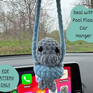 May include: A crocheted blue and gray pool float car hanger. The text "Seal with Pool Float Car Hanger" is written in a teal green circle. The text "PDF PATTERN ONLY" is written in a teal green circle.