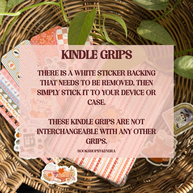 May include: A selection of Kindle grips featuring diverse designs, such as autumnal illustrations and patterns. The grips are presented in a woven basket with green leaves. The image includes the text "Kindle Grips".