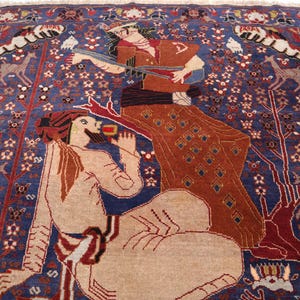 May include: A detailed, hand-woven rug with a deep blue background. The rug features stylized figures in shades of tan, brown, and red, with intricate floral and animal motifs. The design includes deer and trees, creating a rich, artistic tapestry.