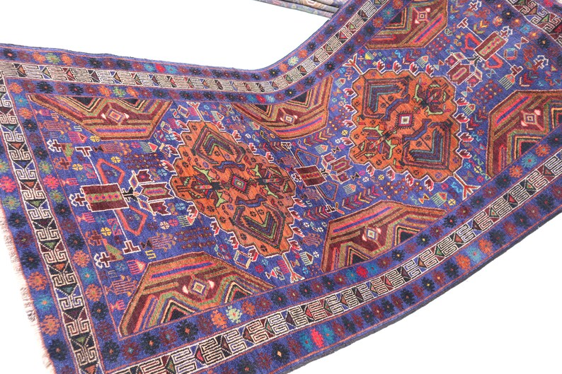 May include: A traditional Persian rug with a blue background and intricate patterns in shades of red, orange, and green. The rug features a central medallion and a border with geometric designs.