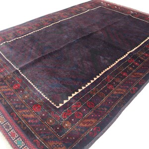 May include: A dark blue rug with a detailed, intricate pattern in shades of red, brown, and green. The rug has a central field with a border of geometric designs.