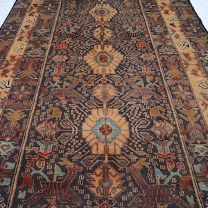 May include: An intricately patterned rug with a dark brown central field, featuring floral and animal motifs in shades of tan, brown, and teal. The rug has a border with a lighter tan color and detailed designs. The overall aesthetic is traditional and decorative.