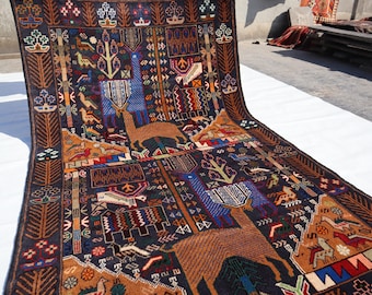 May include: A colourful, hand-woven rug with intricate patterns featuring stylised animals and geometric designs. The rug is primarily dark blue with accents of orange, red, and yellow.