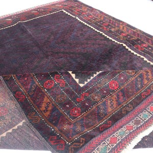 May include: A dark blue and red patterned rug with a fringe border. The rug has a traditional design with intricate details.