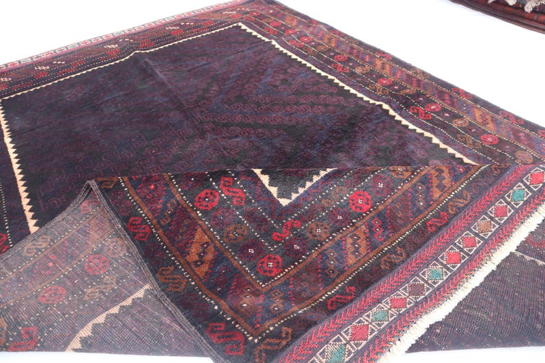 May include: A dark blue and red patterned rug with a fringe border. The rug has a traditional design with intricate details.