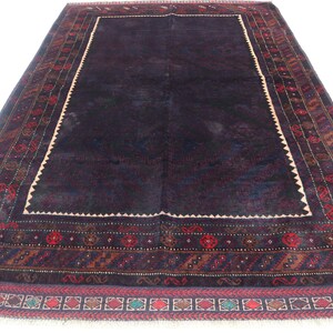 May include: A dark blue rug with a detailed, intricate pattern in shades of red, brown, and cream. The rug has a central field with a border of geometric designs.