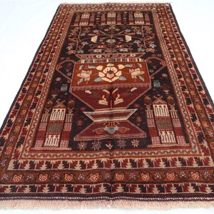 Può includere: Un tappeto persiano tradizionale con sfondo marrone scuro e intricati motivi floreali in tonalità di rosso, crema e beige. Il tappeto presenta un disegno centrale di un vaso con un motivo floreale.
