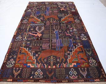 May include: A rectangular, dark brown rug with intricate patterns and animal motifs. The rug features deer, birds, and geometric designs in shades of orange, blue, and green. The rug has a fringed edge.