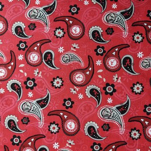 Puede incluir: Tela roja con un patr&oacute;n de paisley que presenta el logotipo de la Universidad de Alabama y un dise&ntilde;o de flores blancas.