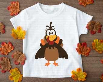 Op de afbeelding: Wit T-shirt met een cartoon-kalkoenontwerp. De kalkoen is bruin met oranje poten en een rode keellap. Hij heeft grote ogen en een verraste uitdrukking.