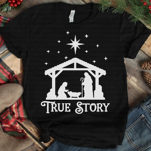 May include: Black t-shirt with a white silhouette of the nativity scene and the text "TRUE STORY".