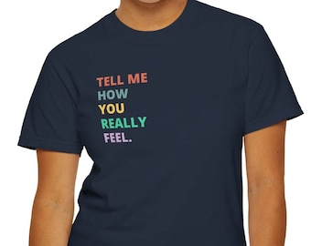 May include: A navy blue t-shirt with the text "TELL ME HOW YOU REALLY FEEL." printed in rainbow colors.