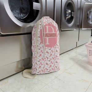 May include: Pink laundry bag with a white drawstring and a pink circle with the letter "P" and the name "PALMER" in white text.