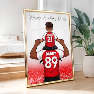 Pu&ograve; includere: Stampa incorniciata con bordo dorato, raffigurante un'illustrazione a cartoni animati di padre e figlio. Il bambino &egrave; sulle spalle del padre, entrambi con maglie rosse e bianche con numeri. Il testo "Happy Birthday Daddy" &egrave; scritto in alto.