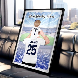 May include: A digital illustration of a father and daughter wearing matching soccer jerseys. The father is holding the daughter on his shoulders. The father's jersey has the number 25 and the words "Daddy" on it. The daughter's jersey has the number 1 and the words "Amelia" on it. The background is a blurred image of a soccer stadium. The text "Best Daddy Ever" is at the top of the image.