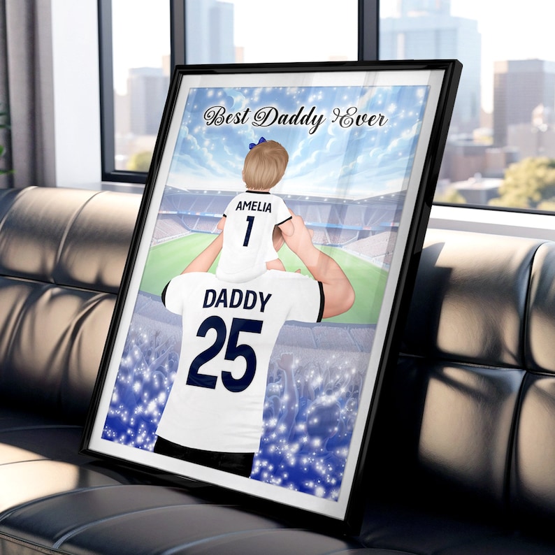 May include: A digital illustration of a father and daughter wearing matching soccer jerseys. The father is holding the daughter on his shoulders. The father's jersey has the number 25 and the words "Daddy" on it. The daughter's jersey has the number 1 and the words "Amelia" on it. The background is a blurred image of a soccer stadium. The text "Best Daddy Ever" is at the top of the image.