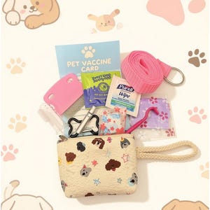 May include: A cream-colored zippered pouch with a pattern of cartoon dog faces and stars, featuring a rope wrist strap. Inside are a pet vaccine card, a pink grooming comb, a pink leash, a Purell wipe, a tick remover tool, and small bags.