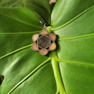 Necklace with wooden and stainless steel pendant representing the symbol of an atom