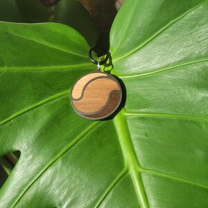 Necklace with circular-shaped wooden and stainless steel pendant, inspired by Yin and Yang