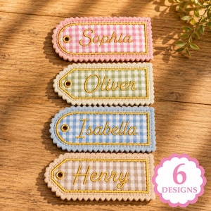 May include: Four rectangular fabric tags with scalloped edges and a gingham pattern in pink, green, blue, and brown. Each tag features a gold-tone metal eyelet and embroidered gold cursive names: Sophia, Oliver, Isabella, and Henry.