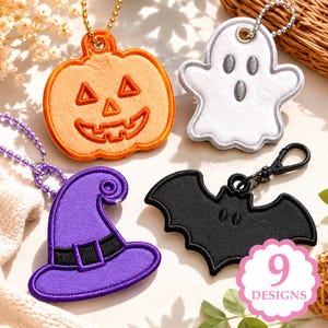 May include: A set of four felt Halloween keychains featuring an orange jack-o'-lantern, a white ghost, a purple witch hat with a black band, and a black bat. Each item includes a metal ball chain or clasp. A pink circular graphic displays 9 DESIGNS.
