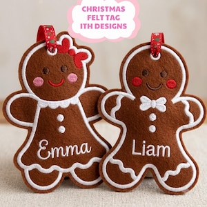 May include: Two brown felt gingerbread person ornaments with white embroidered icing details. One features a red bow and the name Emma, while the other has a white bow tie and the name Liam. Both have red ribbons for hanging at the top.