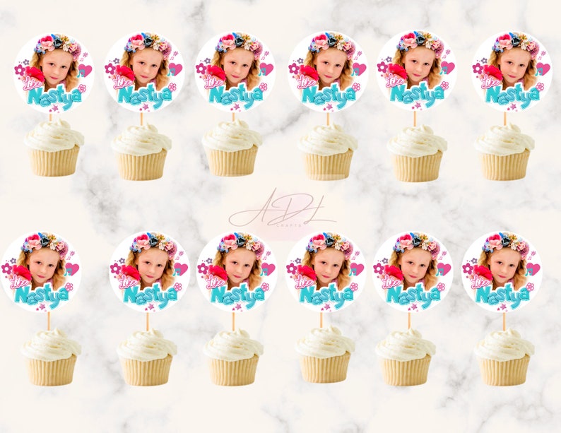 May include: Twelve cupcake toppers with a round, white background featuring a girl's photo, pink and blue flowers, and the text "I love Nastya".