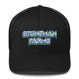 Peut inclure: Casquette de camionneur noire avec un filet blanc à l'arrière. La casquette arbore un logo bleu et jaune qui dit "StoneMan Farms" dans un style rétro 3D.