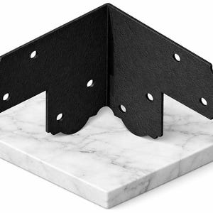May include: Black metal corner brace with decorative scalloped edges and multiple pre-drilled holes. The brace is positioned on a white and gray marble surface, showcasing its design and potential use in woodworking or construction projects.