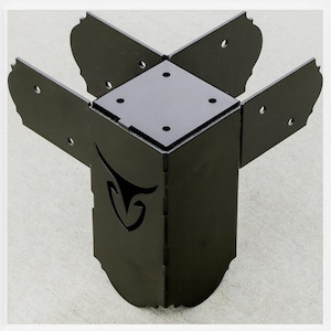 May include: Black metal corner bracket with decorative cut-out design. The bracket has four extending panels with rounded edges and pre-drilled holes for mounting. The corner piece is designed to join two pieces of wood at a 90-degree angle.