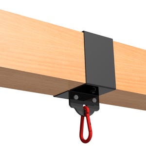 May include: Black metal swing set hanger with a red carabiner clip attached. The hanger is mounted to a wooden beam.