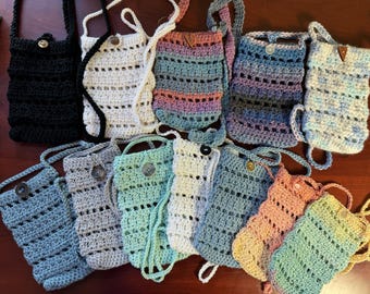 May include: A collection of 12 crocheted bags in various colours and patterns. The bags have a strap and a button closure.