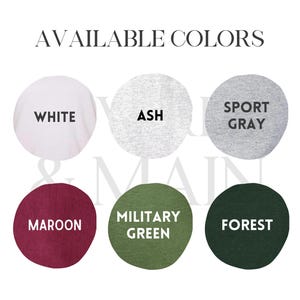 May include: Six color swatches showing available colors for a t-shirt. The colors are white, ash, sport gray, maroon, military green, and forest.