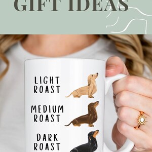 May include: White ceramic coffee mug with a dachshund illustration and the text "Light Roast", "Medium Roast", and "Dark Roast".