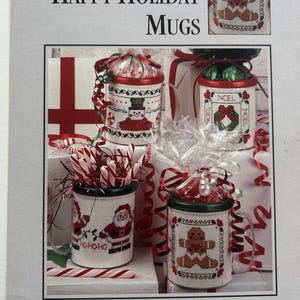 May include: Cross stitch pattern for four festive mugs. The mugs feature a snowman, a gingerbread man, a wreath, and Santa Claus. The pattern is titled "Happy Holiday Mugs".