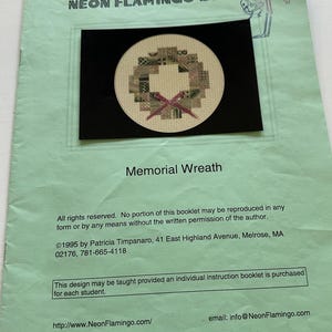 Op de afbeelding: Een kruissteekpatroon voor een herdenkingskrans. De krans is gemaakt van kleine vierkanten in verschillende kleuren en patronen. Het patroon is omgeven door een zwarte rand. De tekst "Memorial Wreath" is onder het patroon gedrukt. De tekst "©1995 by Patricia Timpanaro, 41 East Highland Avenue, Melrose, MA 02176, 781-665-4118" is onder de tekst "Memorial Wreath" gedrukt.