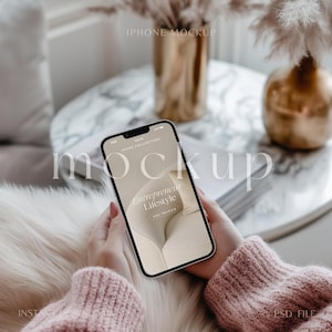 Può includere: Un mockup di iPhone bianco su uno sfondo rosa chiaro e beige. Lo schermo del telefono mostra un sito web con il testo "Entrepreneur Lifestyle" e "Nuova collezione di immagini".