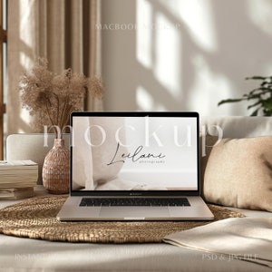 以下が含まれることがあります： 白い画面に「Leilani photography」というテキストが表示されたシルバーのラップトップが、織り込まれたマットの上に置かれています。ラップトップは、ベージュのクッションのある白いソファの上にあります。