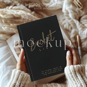 Könnte beinhalten: Ein schwarzes Notizbuch mit einer goldenen Aufschrift, die "Bucket List" lautet, und dem Text "101 Dinge, die ich mit meinem wilden und kostbaren Leben machen möchte".