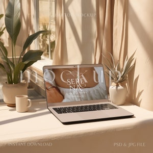 May include: A laptop computer with a white background showing a website for a jewelry store called "Serena Jewelry Store" with the text "Est. 2021" and a seashell logo. The laptop is on a light brown table with a white coffee mug and two potted plants.